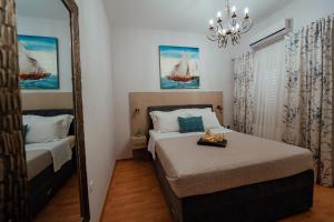 Guesthouse Villa Diana في ماكارسكا: غرفة نوم بسرير ومرآة
