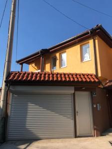 ein Gebäude mit einer Garagentür vor einem Haus in der Unterkunft Villa Bastion in Sarajevo