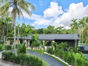 una casa con palmeras delante en VillaKoBo Tennis Golf Pool Bar, en Miami