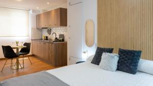 1 Schlafzimmer mit einem weißen Bett und einer Küche in der Unterkunft Pizarro Apartment Malaga in Torremolinos