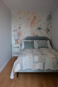 een slaapkamer met een bed met een bloemenmuur bij Apartament Jaskółki w Pilicach in Jastrzębia Góra