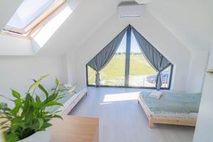 1 dormitorio con 2 camas y ventana grande en Pogodne domki, en Swarzewo