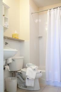 a white bathroom with a toilet and a sink at The Inn at Longshore in Westport