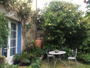 a table and chairs in a garden with an orange tree at 2 DESCARTES in La Flèche