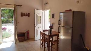 a kitchen with a refrigerator and a table with chairs at NIKOS & SPIROS in Trapezaki