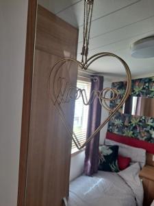 a heart sign hanging over a bed in a bedroom at CALDERA LUXURY LODGE in Tattershall