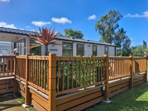 a wooden fence on a deck in front of a house at CALDERA LUXURY LODGE in Tattershall