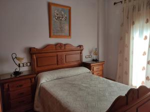 a bedroom with a bed and wooden furniture and a window at ALQUILER CASA PEPA EN CAZORLA in Cazorla