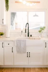 a white kitchen with a sink and a window at Beach Essentials&bikes - Backyard&patios in San Diego