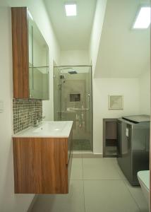 y baño blanco con lavabo y ducha. en Ocean Blue Villa, Flic-en-Flac, en Flic en Flac