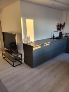 a room with a kitchen with a tv and a counter at Apartment nearby sentrum in Bergen