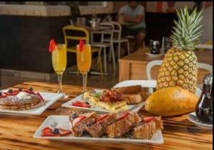 a table with two plates of food and a pineapple at STARFISH LUXURY APARTMENT in San Juan