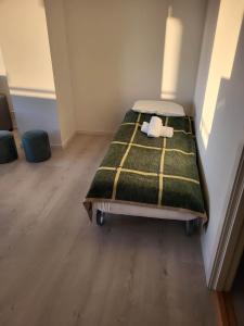 een slaapkamer met een bed met een groene en gele deken bij Apartment nearby sentrum in Bergen