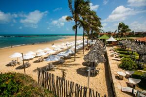 a beach with umbrellas and chairs and the ocean at Sua Cobertura no Tabatinga Beach Resort com a Prosper in Nísia Floresta