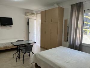 1 dormitorio con cama, mesa y escritorio en Korali apartment, en Sarandë