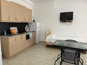 cocina con nevera y mesa en una habitación en Korali apartment, en Sarandë