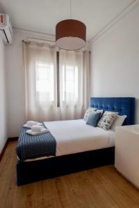 Schlafzimmer mit einem großen Bett mit blauem Kopfteil in der Unterkunft Apartamento do Arquinho I - by VinteOito in Amarante