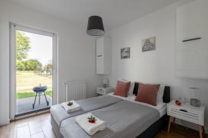 a bedroom with two beds and a large window at Apartamenty Kuracyjna in Jastrzębia Góra