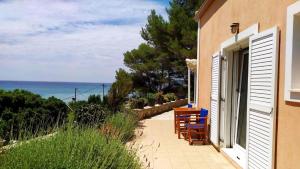 a patio with chairs and a table and the ocean at NIKOS & SPIROS in Trapezaki