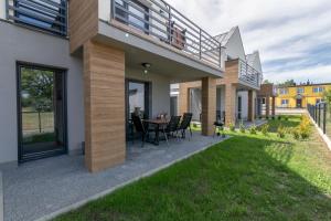 widok na dom z patio i trawą w obiekcie Apartamenty Kuracyjna w Jastrzębiej Górze