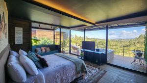 1 dormitorio con 1 cama grande y balcón en Cumbres Luxury Glamping, en Guarne