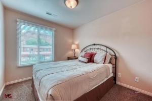 1 dormitorio con cama y ventana en 3BR / 2BA Townhome with Pool, Patio, WiFi, Washer/Dryer en Kanab