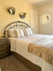 a bedroom with a bed with pillows and a mirror at 3BR / 2BA Townhome with Pool, Patio, WiFi, Washer/Dryer in Kanab