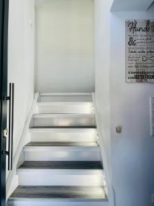 einen Flur mit Treppe mit Schild an der Wand in der Unterkunft Apartment Lindenstein in Fritzlar