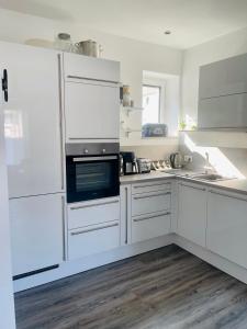 a kitchen with white cabinets and a stove top oven at Apartment Lindenstein in Fritzlar