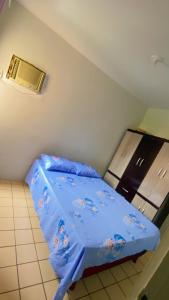 um pequeno quarto com uma cama com um edredão azul em Shangrila 2 em Maceió