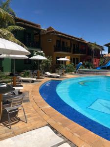 - une piscine avec des chaises et des parasols à côté d'un bâtiment dans l'établissement Costa Marlin Hotel, à Guriri