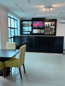 a bar with a table and chairs and a television at Maxx Msquare Hotel in Agege