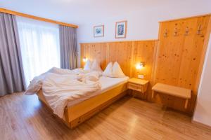 sypialnia z dużym łóżkiem i drewnianą ścianą w obiekcie Bergerhof w mieście Ramsau am Dachstein