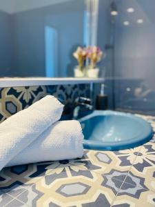 a bathroom with a sink with towels on a counter at Appartement lumineux entre Mer et Campagne in Pordic