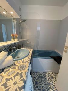 La salle de bains est pourvue d'un lavabo et d'une baignoire. dans l'établissement Appartement lumineux entre Mer et Campagne, à Pordic