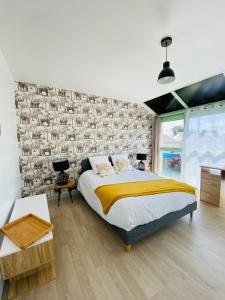 a bedroom with a bed and a stone wall at Appartement lumineux entre Mer et Campagne in Pordic