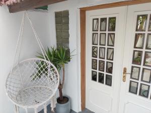 a white swinging chair in front of a door at Refúgio do Esquilo in Marinha Grande