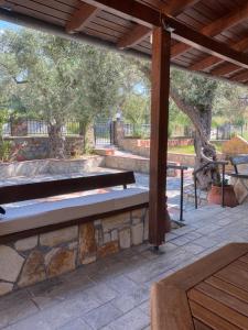 a wooden bench sitting on a patio under a pavilion at Agia Paraskevi Villa Olive in Mákri