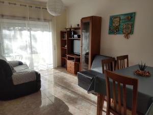 a living room with a table and a couch and a television at Apartamento- csantos in Olhos de Água