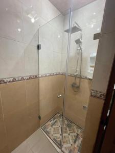 a shower with a glass door in a bathroom at dar leena in Essaouira