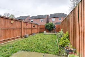 a backyard with a fence and a yard with plants at Simitach Serviced Apartments in Middleton