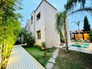 uma villa com uma piscina e uma casa em SABOR VILLA TARGA GARDEN -Only Family em Marraquexe