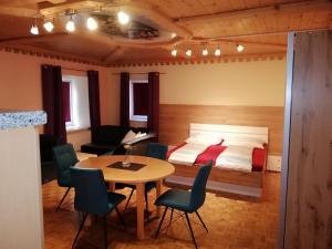 a bedroom with a bed and a table and chairs at Zimmer und Appartement Marktcafe Sankt Peter am Kammersberg 87 in Sankt Peter am Kammersberg