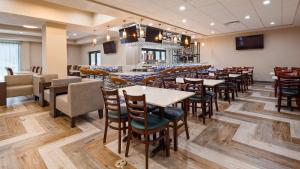a restaurant with tables and chairs and a bar at Hotel Manhattan, BW Signature Collection in New Caney