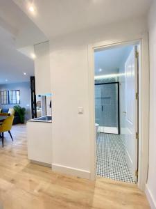 Una cocina blanca con una puerta que da a una sala de estar. en AM II Segovia VUT en Segovia