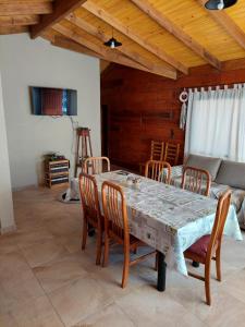 a dining room with a table and chairs and a couch at Rancho la alborada in Los Reartes
