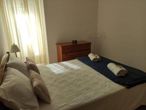 a bedroom with a bed with two pillows on it at Apartamento- csantos in Olhos de Água