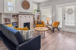 een woonkamer met een bank en een open haard bij BeeKeeper's Inn - Beautifully Renovated 1929 Bungalow with 2 Bedrooms on Brick Street near Tampa's Attractions in Tampa