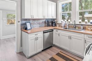 a kitchen with white cabinets and a sink at BeeKeeper's Inn in Tampa
