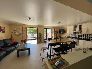 a kitchen and living room with a couch and a table at AS CEGONHAS - ALOJAMENTo LOCAL in Olhão